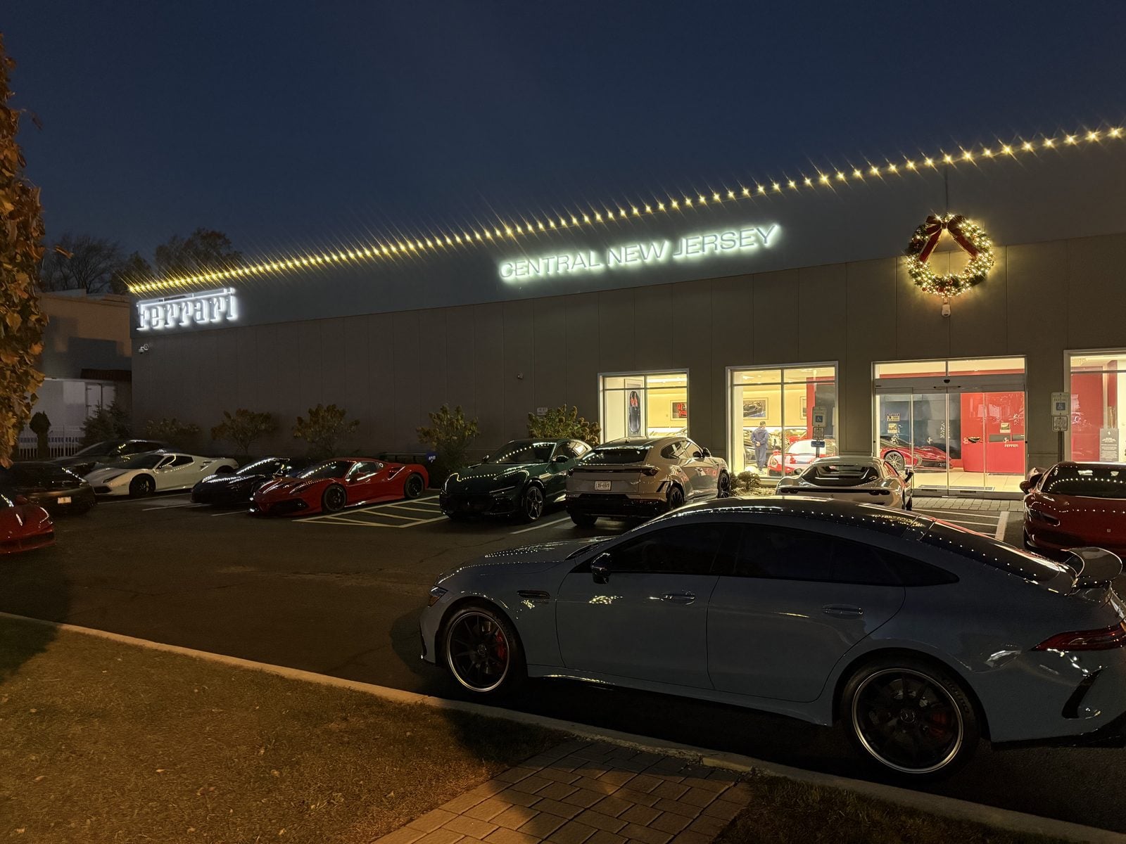A Ferrari dealership in central New Jersey at dusk, its roofline outlined in warm bulbs