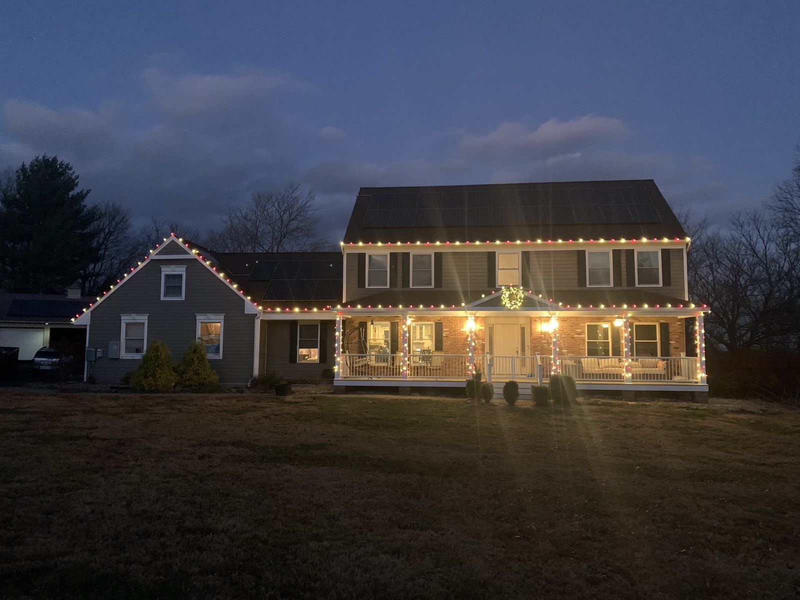 A long low house at blue hour with bulbs following the roofline