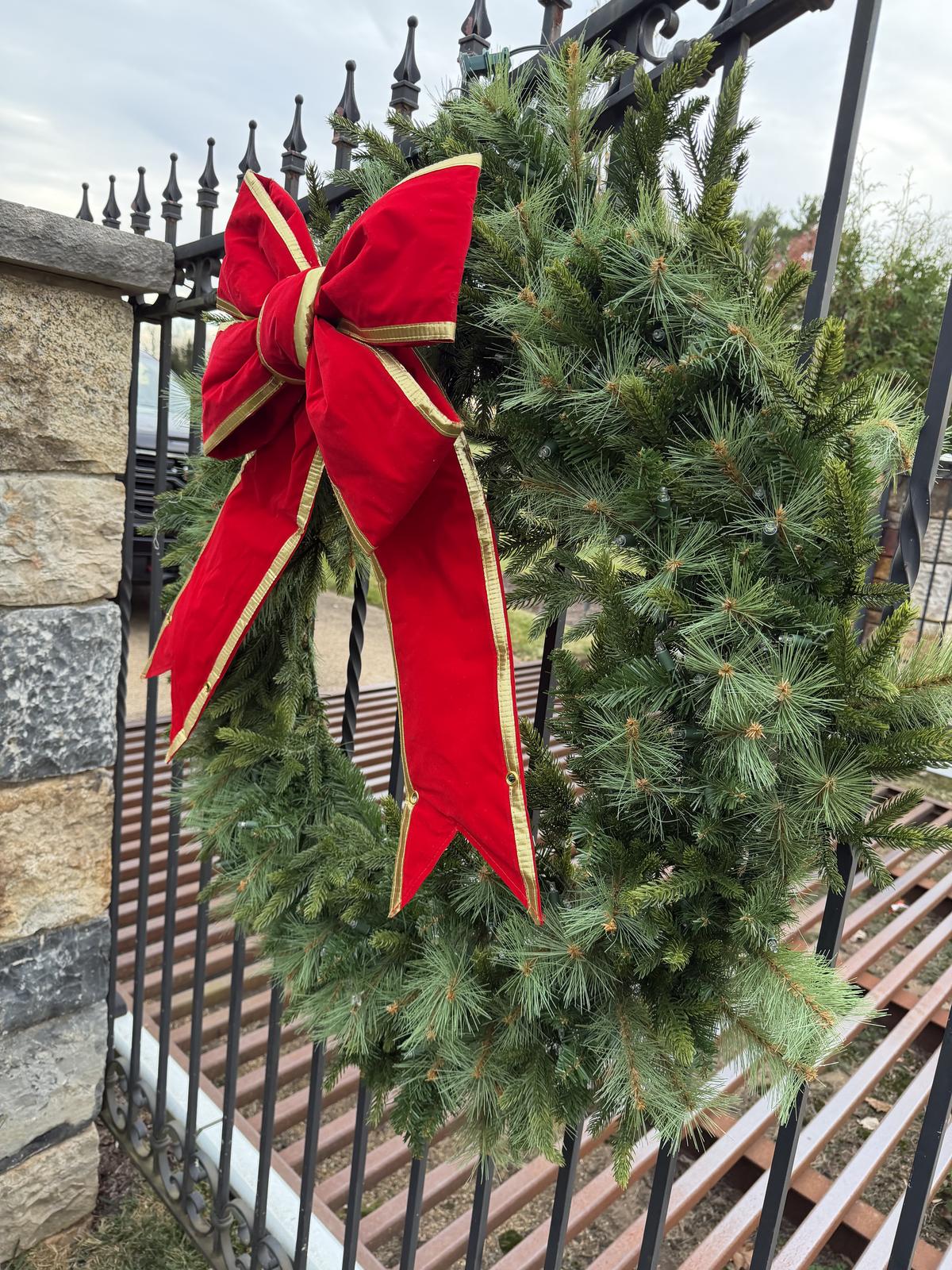 A close view of a red velvet bow on a lit garland