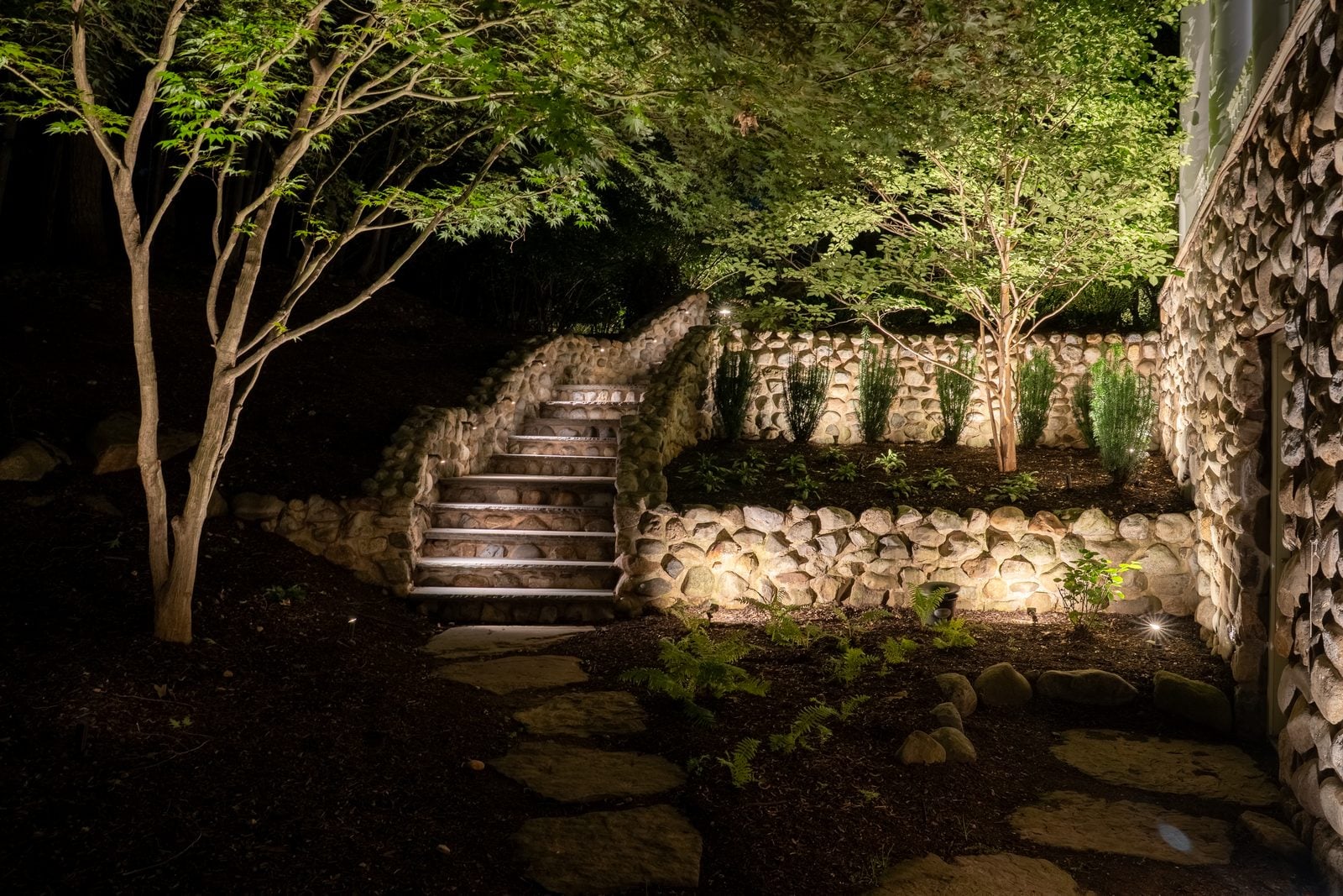 A flight of steps in a stone wall, each riser lit from the side