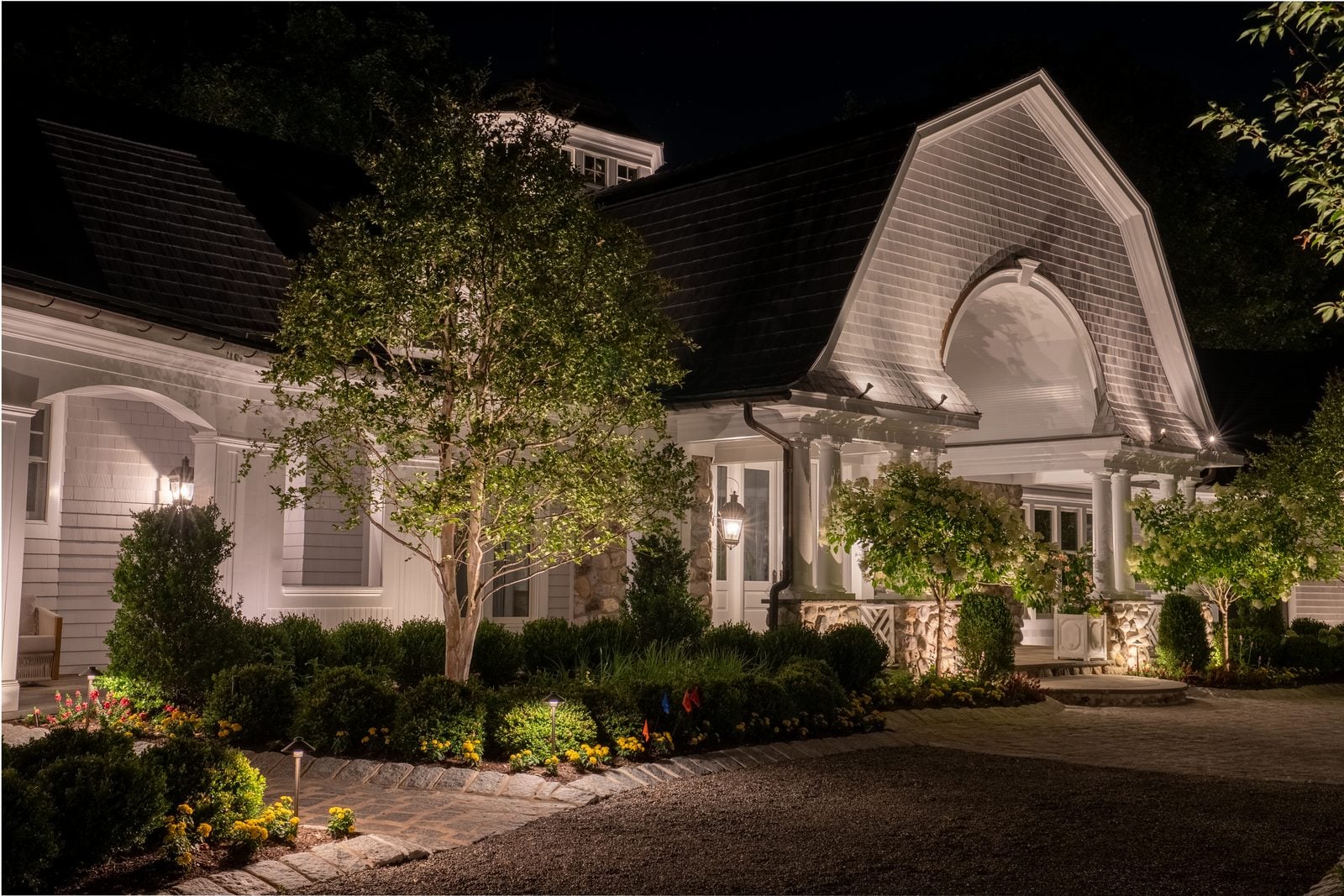 A New Jersey home at night with its facade washed in warm light from ground-set fixtures