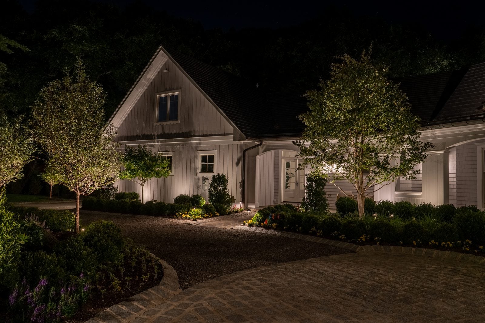 A house front lit after dark, the roofline and entry picked out against the night