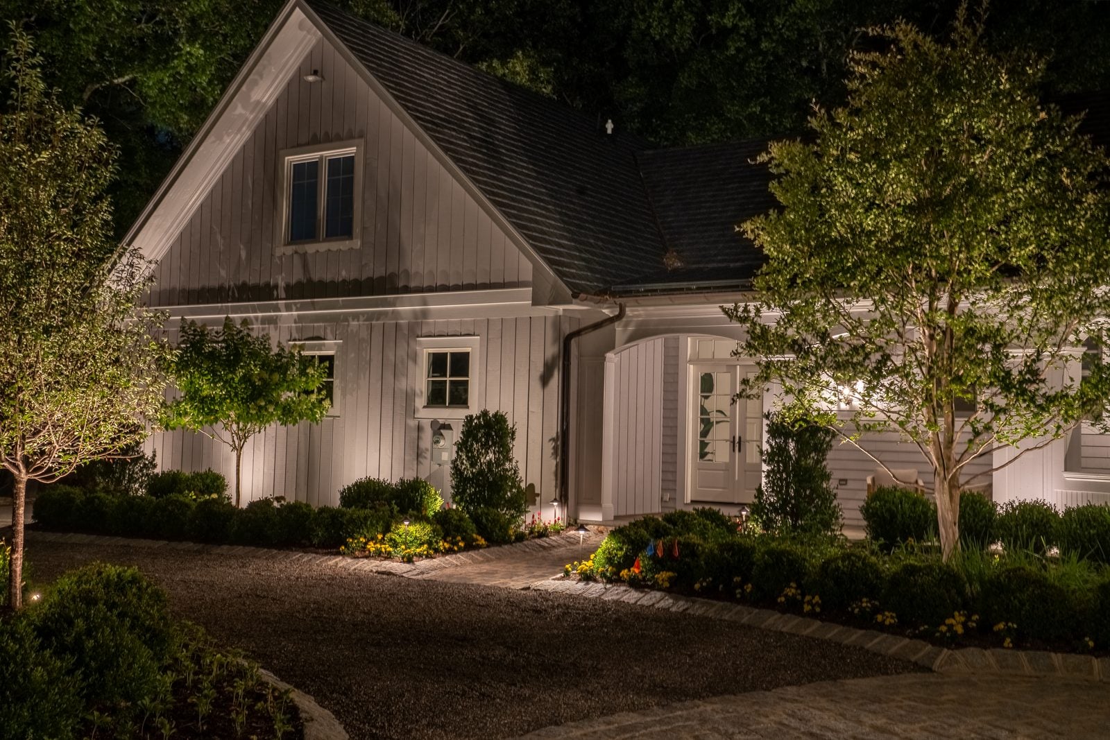 Warm light grazing the front of a home, gables and stonework brought forward