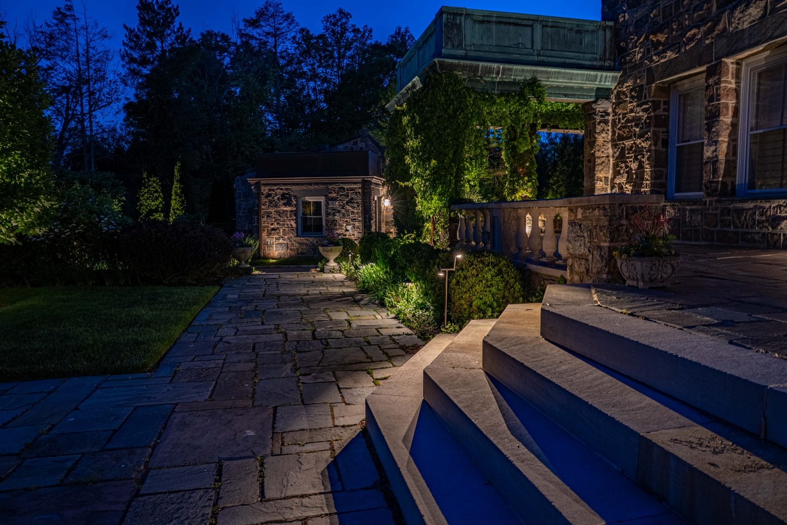 A flight of steps in a stone wall, each riser lit from the side