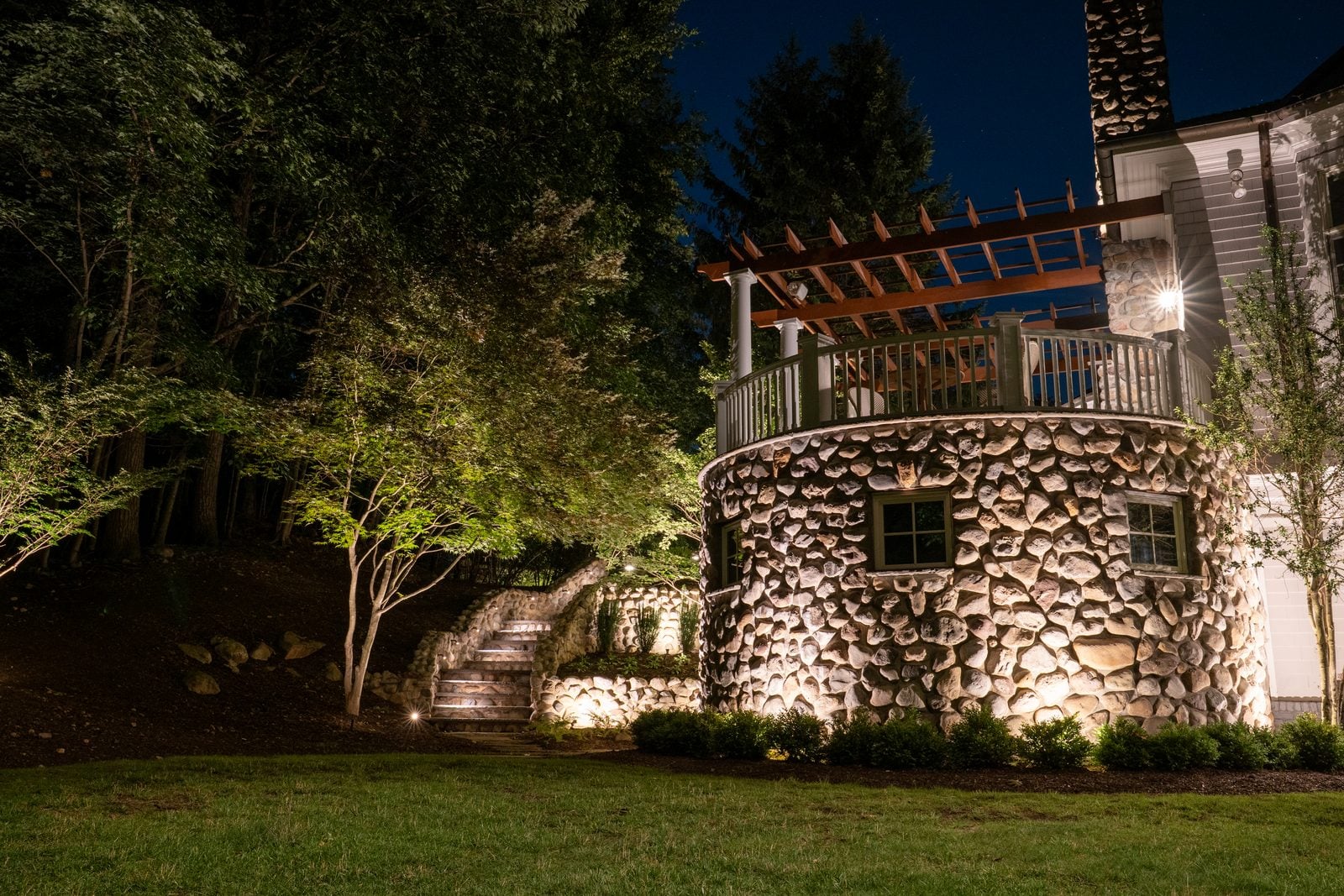 A New Jersey home at night with its facade washed in warm light from ground-set fixtures