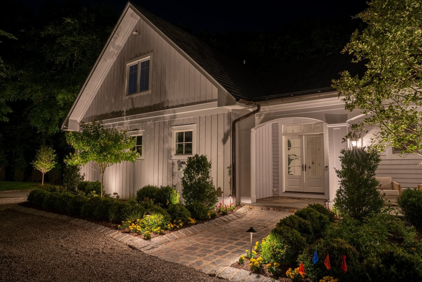 Warm light grazing the front of a home, gables and stonework brought forward
