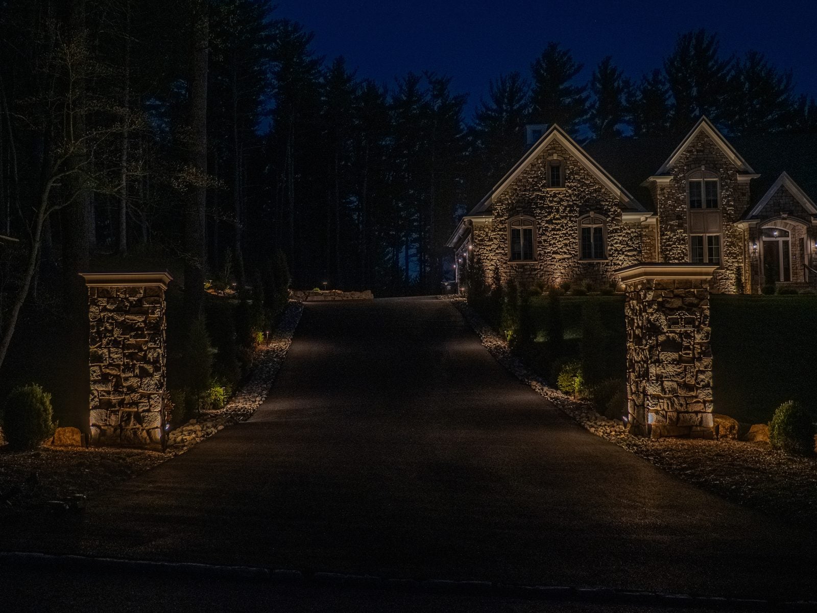 A New Jersey home at night with its facade washed in warm light from ground-set fixtures
