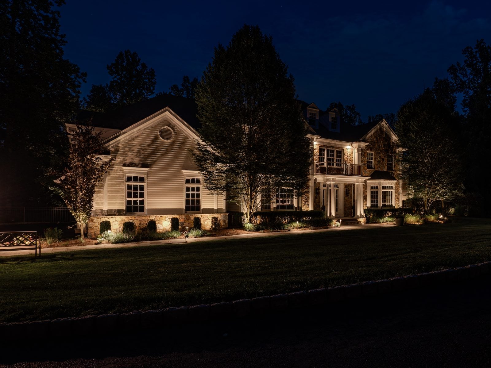 Warm light grazing the front of a home, gables and stonework brought forward