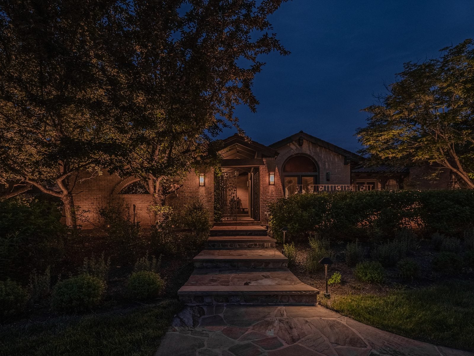 A New Jersey home at night with its facade washed in warm light from ground-set fixtures