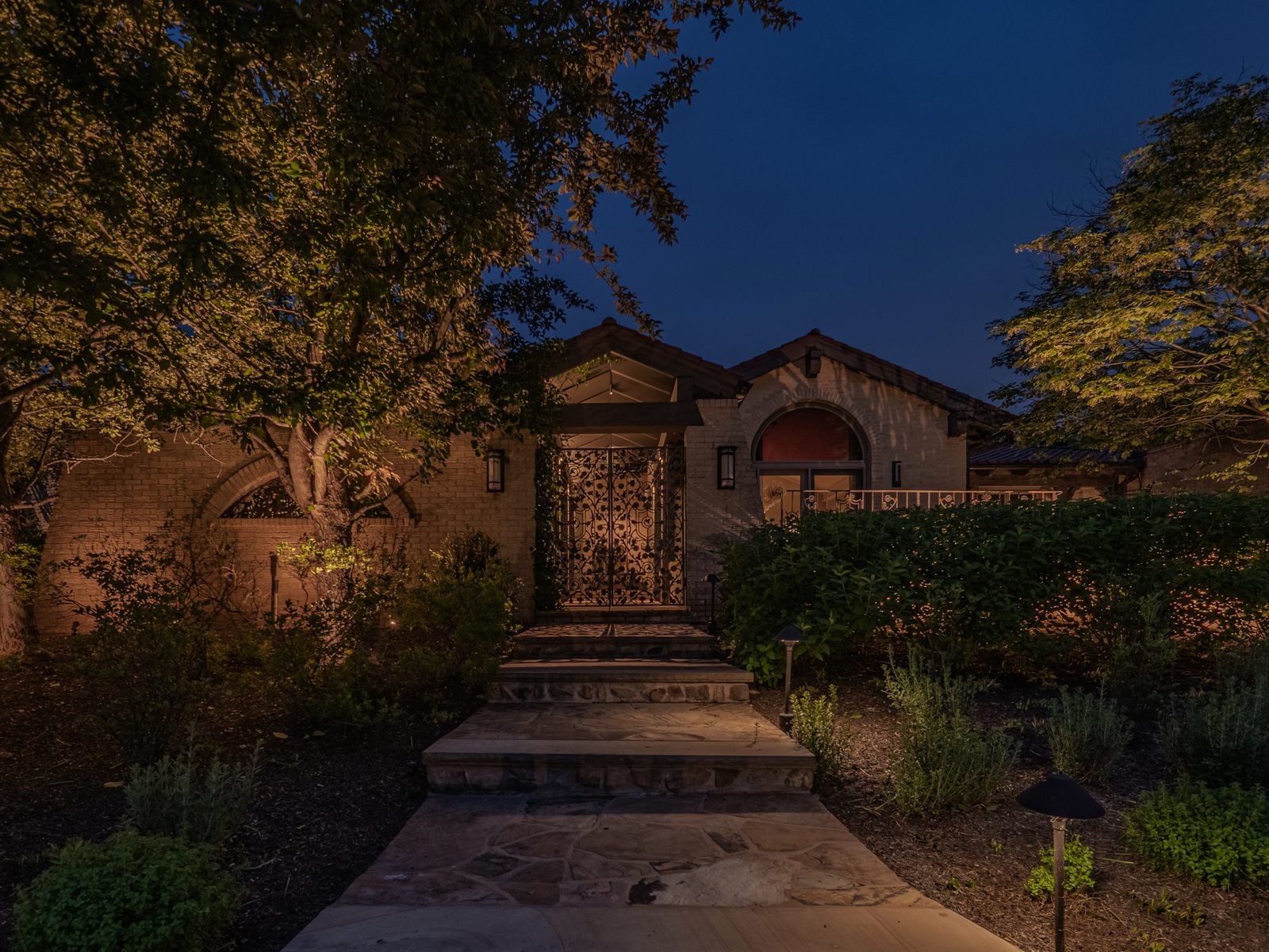 A house front lit after dark, the roofline and entry picked out against the night