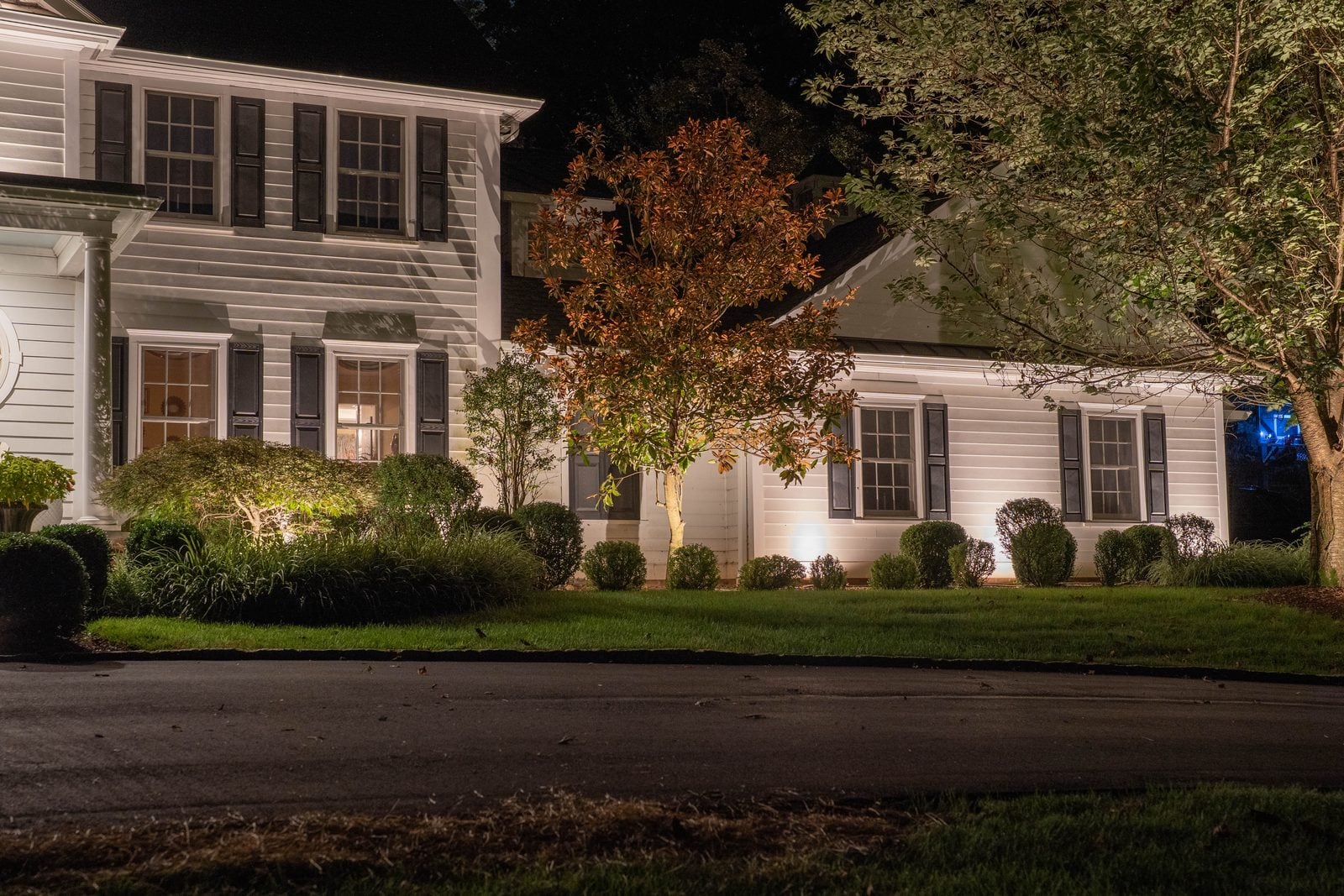 A house front lit after dark, the roofline and entry picked out against the night