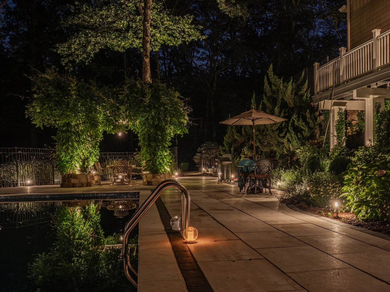 A patio lit after dark, the surrounding beds and structure brought up in light