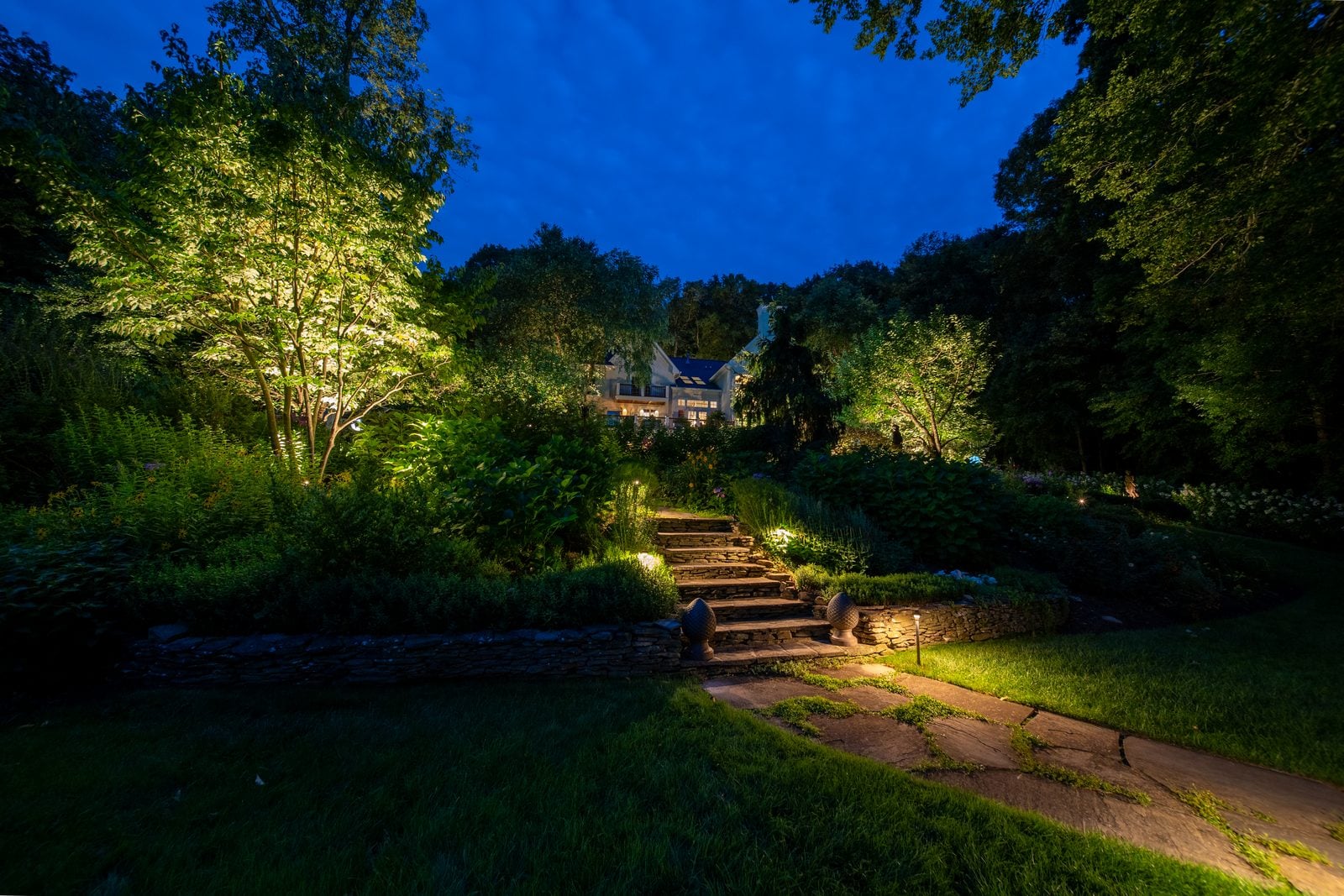 A flight of steps in a stone wall, each riser lit from the side