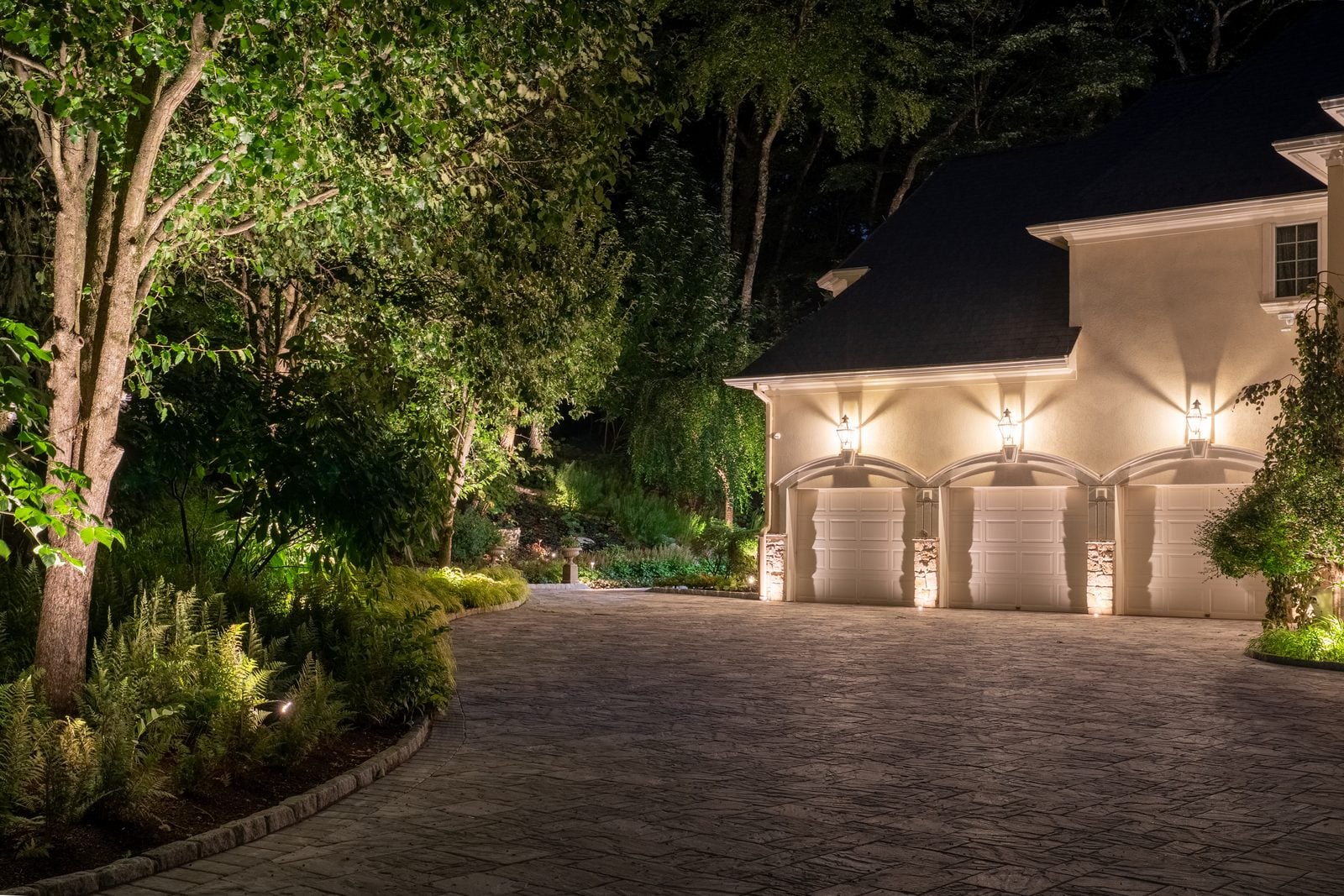 A house front lit after dark, the roofline and entry picked out against the night