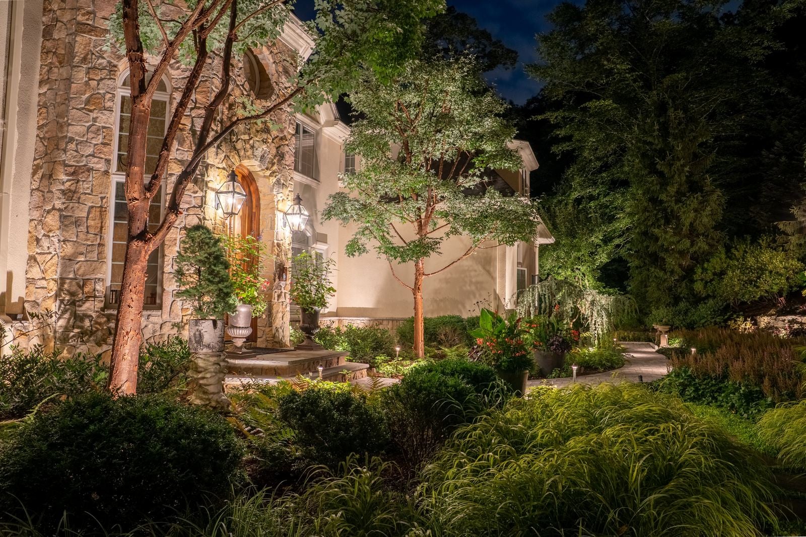 Warm light grazing the front of a home, gables and stonework brought forward