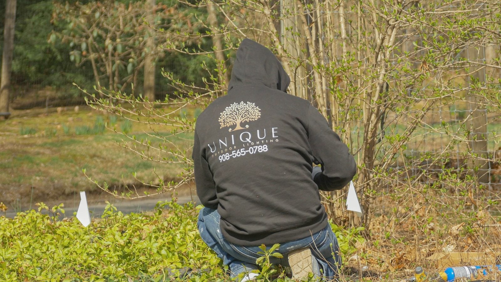 Unique Outdoor Lighting crew working a planting bed during a daytime install