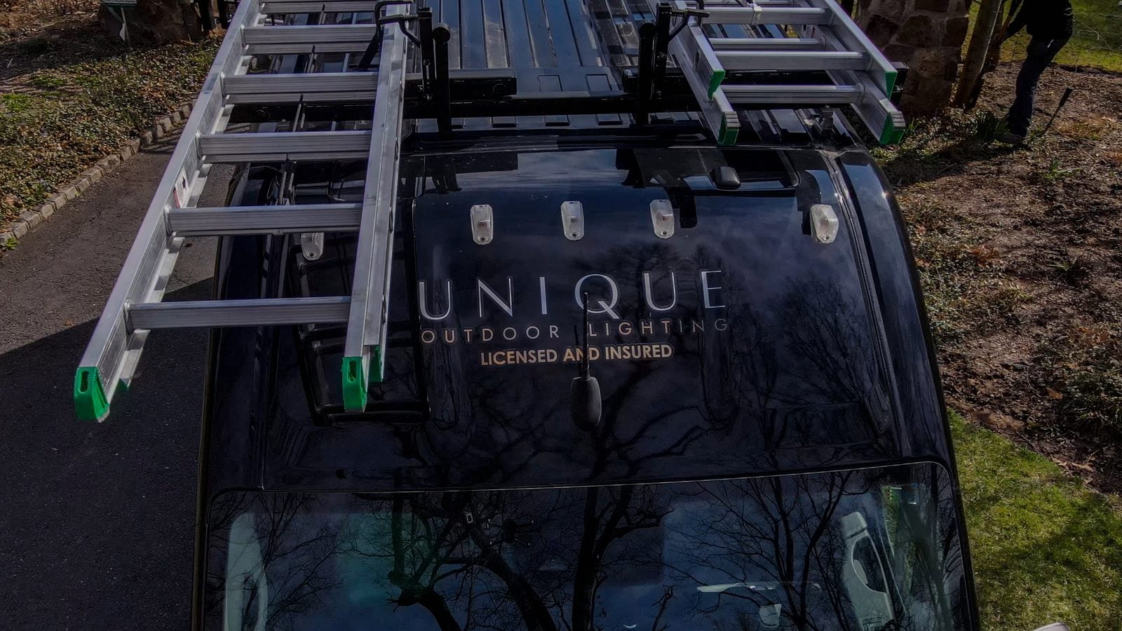 A Unique Outdoor Lighting van on site, marked licensed and insured